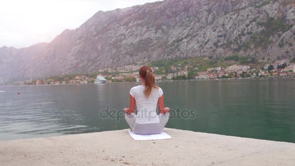 Hermoso yoga con increíble vista al mar sobre fondo, mujer bastante saludable con cuerpo perfecto de pie en una de pose de yoga — Vídeos de Stock