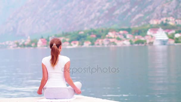 Bello yoga con splendida vista sul mare sullo sfondo, bella donna sana con stand corpo perfetto in uno di posa yoga — Video Stock