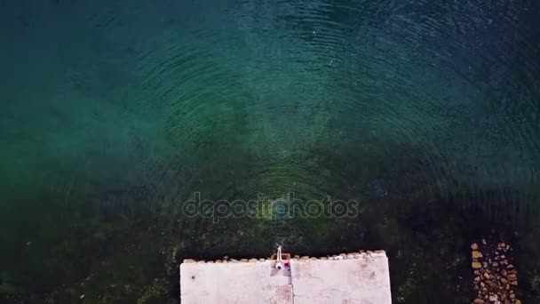 Zoomina fotografica. Gambe femminili spruzzando acqua di mare. Vista aerea . — Video Stock