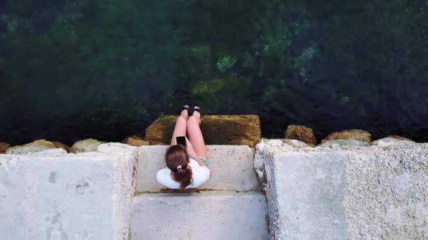 Žena používající smartphone na pohled shora moře. — Stock video