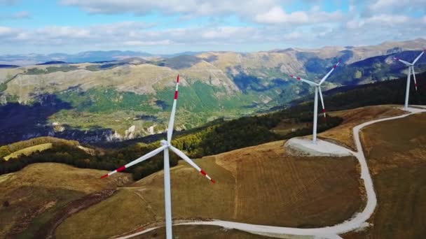 Luchtfoto zonne-boerderij en Turbines in Europa zonnepanelen energie bij zonsondergang met de bergen op de achtergrond. — Stockvideo