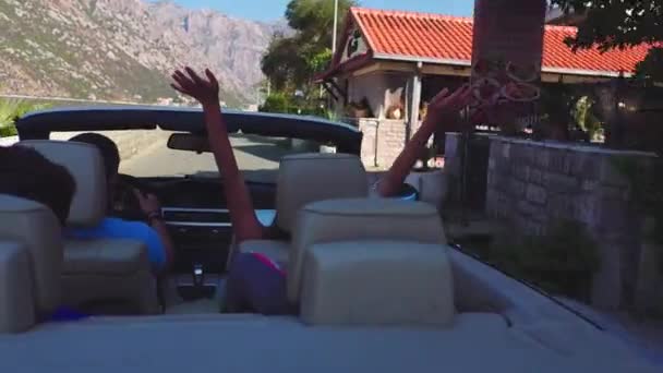 Vista trasera de una pareja sentada en un coche elevando su coche — Vídeos de Stock