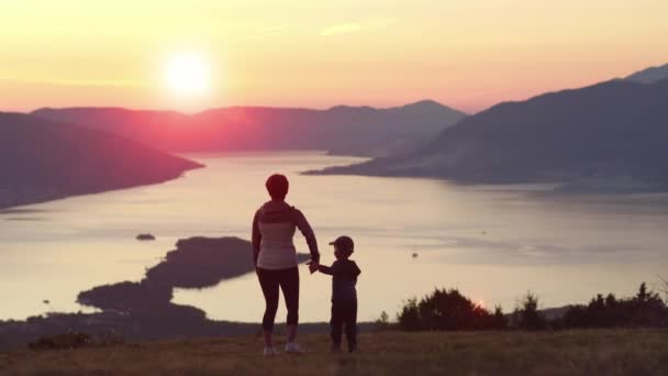 Anya és fia keresi a naplementét a hegy — Stock videók