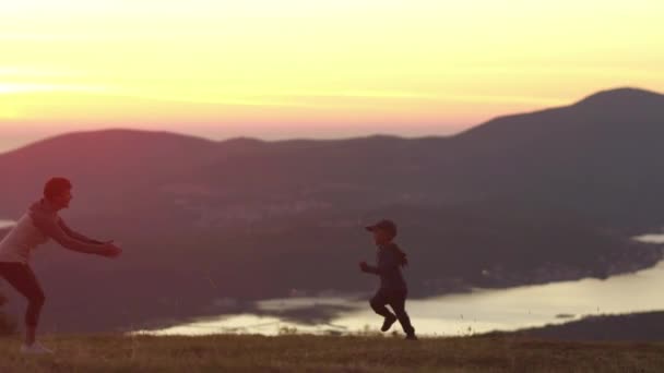 Au ralenti. Garçon courant à son moter au coucher du soleil dans les montagnes — Video