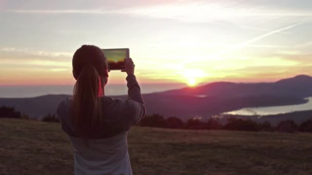 Femme randonneur utiliser tablette numérique prendre des photos au sommet de la montagne falaise — Video