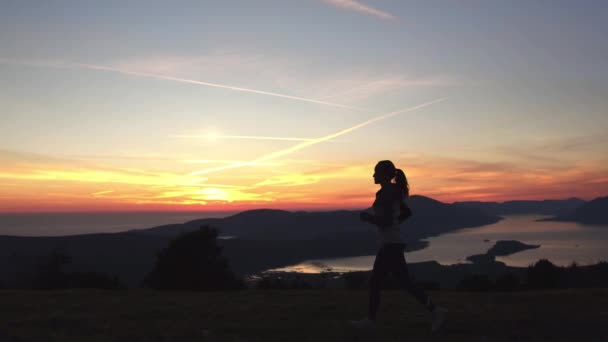 Жінка біжить в горах під сонячним світлом . — стокове відео
