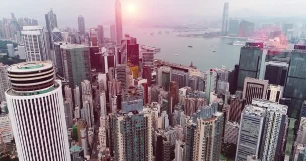 AERIAL. Linha do horizonte de Hong Kong. Hongkong hdr paisagem urbana aérea com sol por do sol. Panorama incrível de edifícios e céu refletindo no porto — Vídeo de Stock