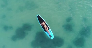 Çekici kadın bikini taşıma kamera sörf tahtası üzerinde havadan görünümü güneşlenme