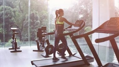Spor salonunda treadmill şirin Asyalı kız. Panoramik pencere, sağlıklı fitness yaşam tarzı kavramı