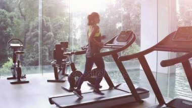 Ağır çekim. Spor salonunda treadmill şirin Asyalı kız. Panoramik pencere, sağlıklı fitness yaşam tarzı kavramı