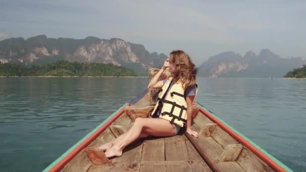 Young Happy Mixed Race Girl Sentarse y relajarse en el tradicional barco tailandés de madera de cola larga en el lago Khao Sok. Provincia de Phang Nga, Tailandia. — Vídeos de Stock