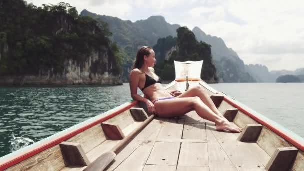 Reisenden Frau im Bikini entspannen auf Holzboot und suchen Destination Insel, andaman Meer, mu koh surin Nationalpark, phangnga, Reisen in Thailand, Sommerurlaub und Outdoor-Urlaub Reise