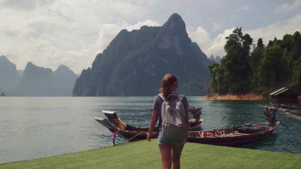 Young woman backpacker enjoy landscape view of mountain with long traditional thai boat, Asia, Thailand. — Stock Video