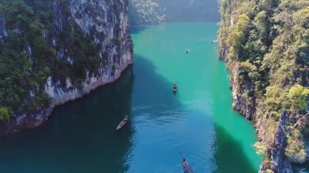 Luchtfoto. Mooie luchtfoto bovenaanzicht van groep traditionele Thaise boten varen tussen de enorme bergen. Khao Sok Nationaalpark in Surat Thani zuiden van Thailand. Soortgelijke naar Guilin, China. — Stockvideo