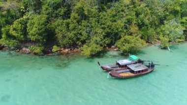 AERİAL. İnsansız hava aracı, temiz su, beyaz plaj ve geleneksel uzun kuyruklu teknelerle tropikal körfezin altında uçuyor. Trquoise suyu. Paradaise Adası, Tayland.