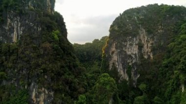 Hava. Büyük dağlar ve yağmur ormanı Tayland güneyinde şaşırtıcı sinema tarzı video. Drone uçuş pik üzerinden. Güneş dağların arkasında fişekleri. Quadrocopter yakınındaki iki kuş uçuş.