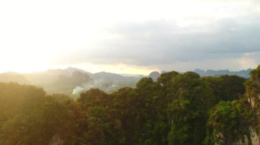 Hava. Tayland harika manzara sinema tarzı video. Yağmur bulutları, dağlar ve yeşil alan günbatımında görüntüleyin. Hareketli kamera üst aşağı ve dağın arkasında yavaş.