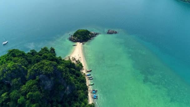 AERIAL. Vista superior de pequena ilha tropical isolada com praia de areia branca e água azul transparente e recifes de coral. Tiro aéreo, lanchas, barcos de cauda longa, ilha de Khai Nok, Phuket, Tailândia . — Vídeo de Stock
