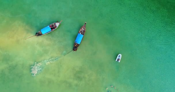 AERIAL. Camera following the boat at blue lagoon. Top view of isolated rocky tropical island with turquoise water and white beach. — Stock Video