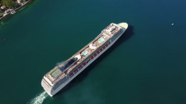 AERİAL. Yüksek uçuş ve büyük lüks yolcu gemisinin üst görüntüsü hava görüşünde gün doğumunda liman kanalından denize açılmaya devam ediyor.
