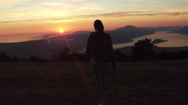 Kadın başarılı hiking tırmanma siluet Dağları'nda, motivasyon ve ilham yatay Adası ve okyanus. Uzun yürüyüşe çıkan kimse ile silah kadar güzel manzaraya bakarak dağ tepe üzerinde uzanmış.