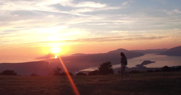 Κινηματογραφικό στυλ. Yong περπάτημα γυναίκα. Σπορ γυναίκα το περπάτημα στο βουνό στο ηλιοβασίλεμα. Φανταστική θέα. — Αρχείο Βίντεο