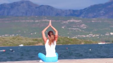 denizin içinde belgili tanımlık geçmiş ile sahilde yoga egzersizleri yapıyor kadın yardım detay