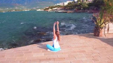 Rüzgar ve Adriyatik Denizi, büyük dalgalar. Genç Asyalı kadın Yoga villa pier özel poz. Spor kadın renksizdir, Avrupa'nın Adriyatik Denizi manzaralı mountan yoga yaparken blu ve Beyaz giysili.