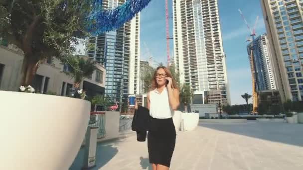 Adulto Caucasiano Confiante Jovem Empresarial Mulher de Camisa Branca está Falando no Telefone Fora perto de Edifício de Escritório Moderno. Medium Long Low Angle 4K Slow Motion Corporate Shot — Vídeo de Stock