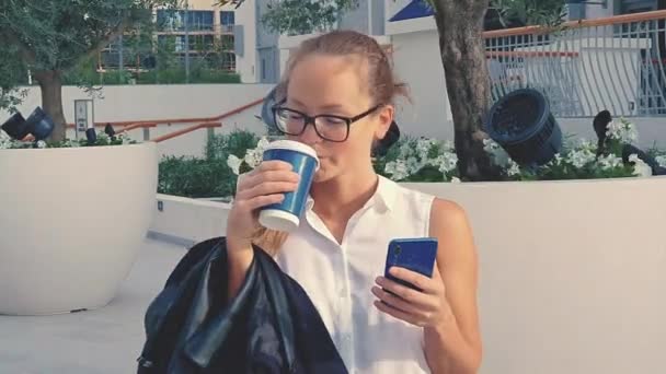 Senhora do escritório segurando café e celular, andando na rua para o trabalho. recém-formado começou a trabalhar no centro da cidade de LA. Estilo de vida jovem trabalhador feminino . — Vídeo de Stock