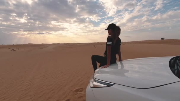 Una joven viajera sentada en el coche en el desierto. Concepto de viaje. — Vídeo de stock