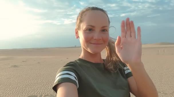 Jonge vrouw met frontale camera en praten door de vudeo. zelfportret van een jonge vrouw op vakantie in de woestijn — Stockvideo