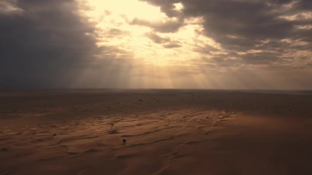 AERIAL. A luz do pôr-do-sol brilha em Great Sand Dunes nos Emirados Árabes Unidos. HDR pôr do sol dramático no deserto. — Vídeo de Stock