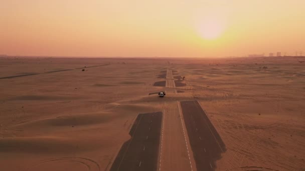 AERIAL. Viajantes de pé em seu carro na estrada arenosa no deserto . — Vídeo de Stock