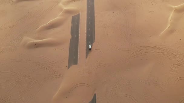 空中だ砂嵐の後の砂漠の道路上の白い車の運転のトップビュー. — ストック動画