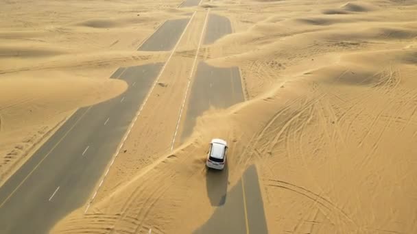 Аріале. Вид зверху на білий автомобіль, що їде по пустельній дорозі після піщаної бурі . — стокове відео