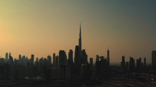 Szenische Luftaufnahme des Sonnenuntergangs einer modernen Großstadt im Zeitraffer, Wolkenkratzer, Bürogebäude und die Silhouette des Burj al-Arab im Hintergrund. Business bay, Dubai, Vereinigte Arabische Emirate. — Stockvideo