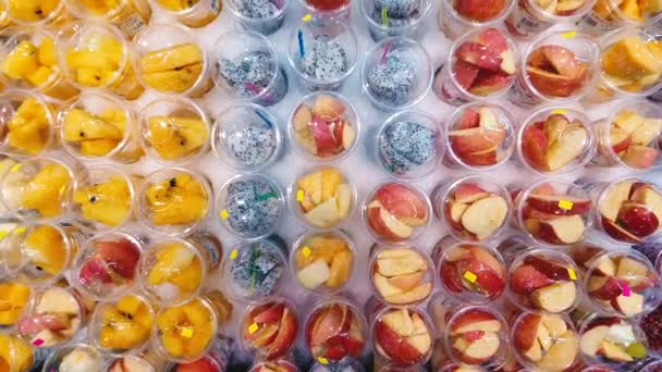 女人在超市里吃新鲜的切碎水果. 食物、健康饮食和素食概念. — 图库视频影像