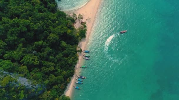 AERIÁLIS. Top kilátás zöld sziget és strand hagyományos thai hajó a naplementében. — Stock videók