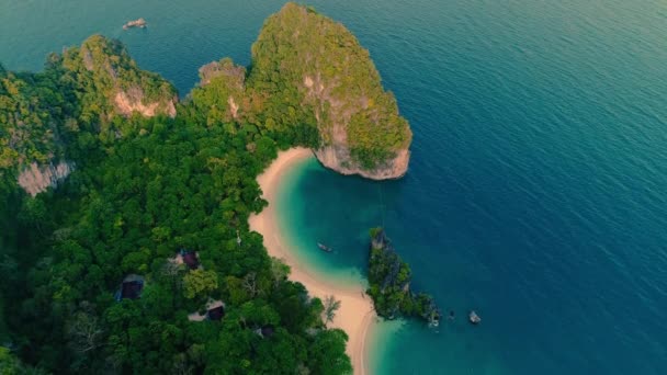 AERIAL. Blick von oben auf grüne Insel und Strand mit traditionellem Thai-Boot bei Sonnenuntergang. — Stockvideo