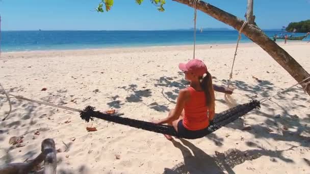 Mujer en camiseta naranja y sombrero en la playa en hamaca. — Vídeo de stock