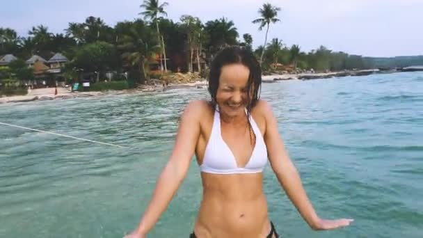 Glada vackra kvinnan splashin vatten på hennes ansikte i havet, skrattar. — Stockvideo