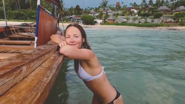 Droom concept: vrouw zittend in oude houten boot op het strand in Thailand — Stockvideo