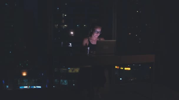 Masadaki kadın, geceleri dizüstü bilgisayarda çalışıyor. Karantina zamanı kavramı. — Stok video