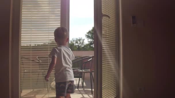 Ребенок открывает окно и смотрит в окно. Оставайтесь дома и займитесь карантином. Изоляция вспышки — стоковое видео