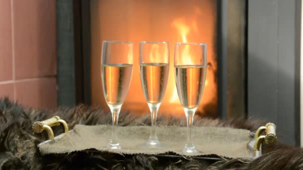 Perto da lareira três copos com champanhe — Vídeo de Stock