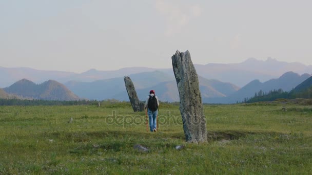 Mulher turista examina antigos stelts de pedra do período turco nas montanhas Altai — Vídeo de Stock