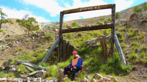 矿业工程师，一名穿着防护反光背心、手套和头盔的地质学家，手里拿着锤子. — 图库视频影像