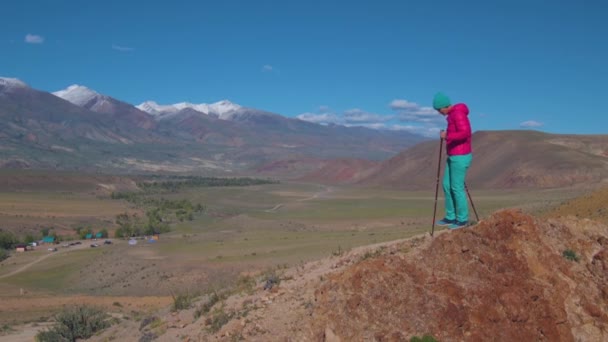 Een toerist met Zweedse stokken is blij met het prachtige berglandschap — Stockvideo