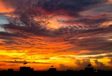 Şehir silueti günbatımı ile canlı kırmızı bulut gökyüzü üzerinde
